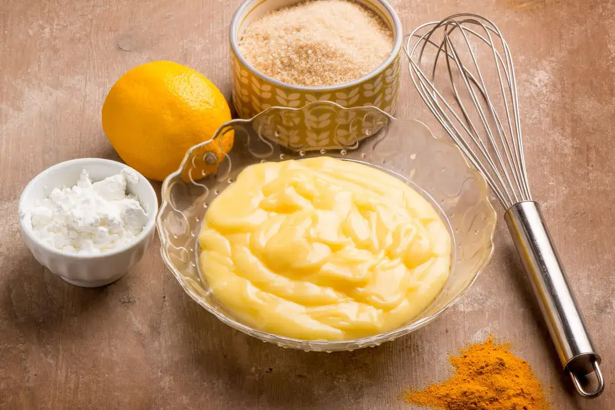Crema al limone senza uova, pronta per essere gustata. Ingredienti: limone, zucchero, amido, frusta.
