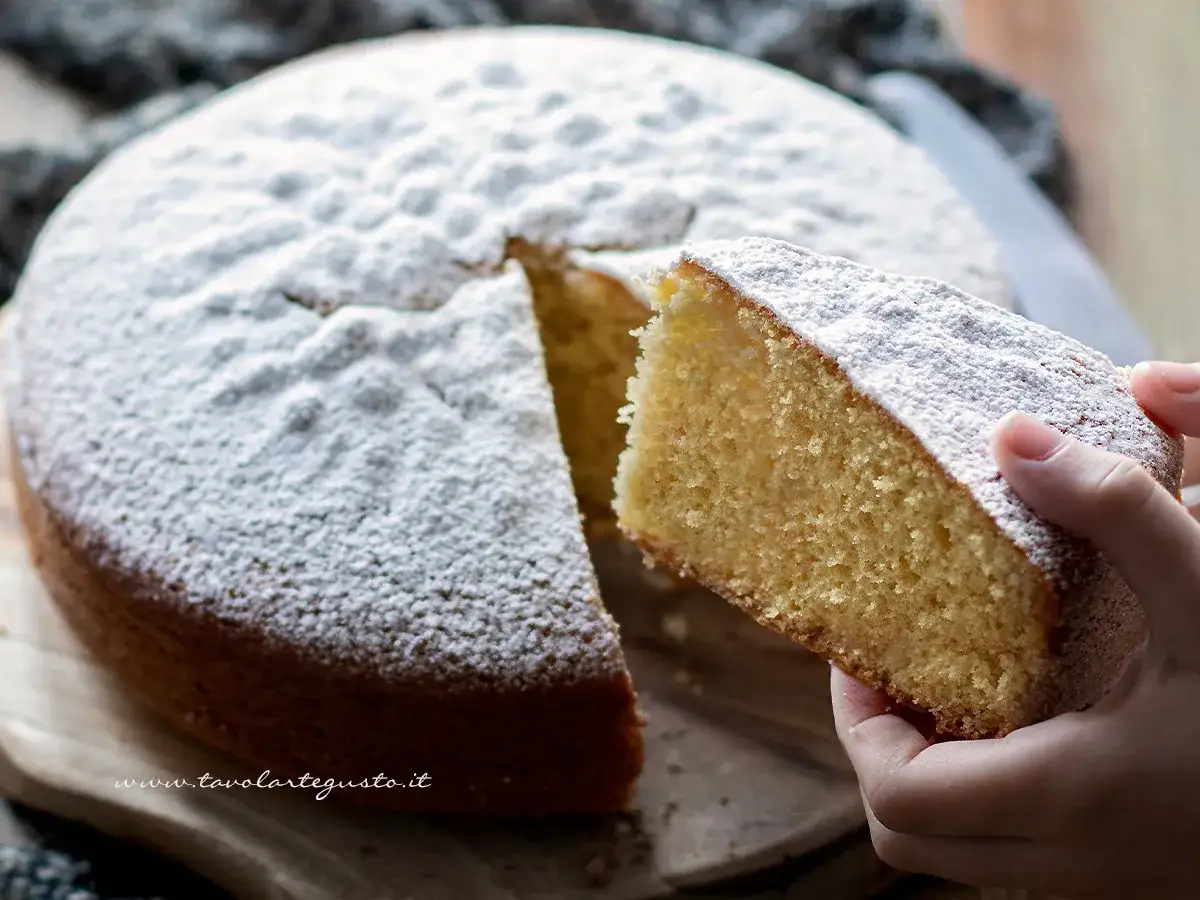 La fetta di torta soffice e alta, cosparsa di zucchero a velo, rivela il segreto per torte alte e soffici.