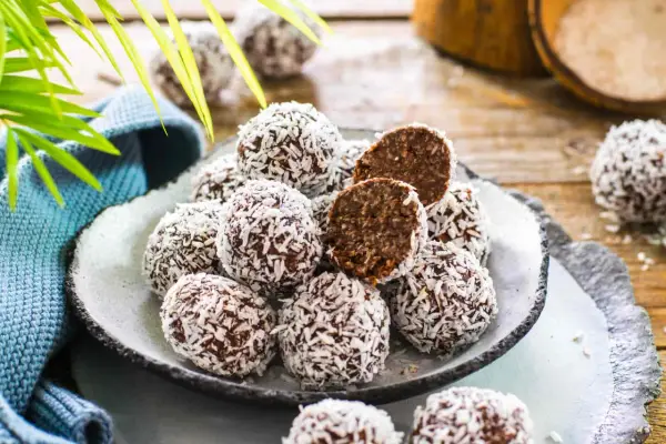 Praline al cioccolato facili e veloci, ricoperte di cocco grattugiato. Un morso rivela un interno morbido e goloso.