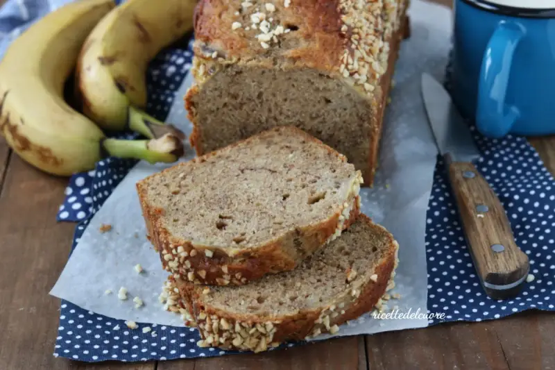 Fetta di banana bread senza burro, soffice e profumato, con croccante copertura di frutta secca. Perfetto per la colazione.